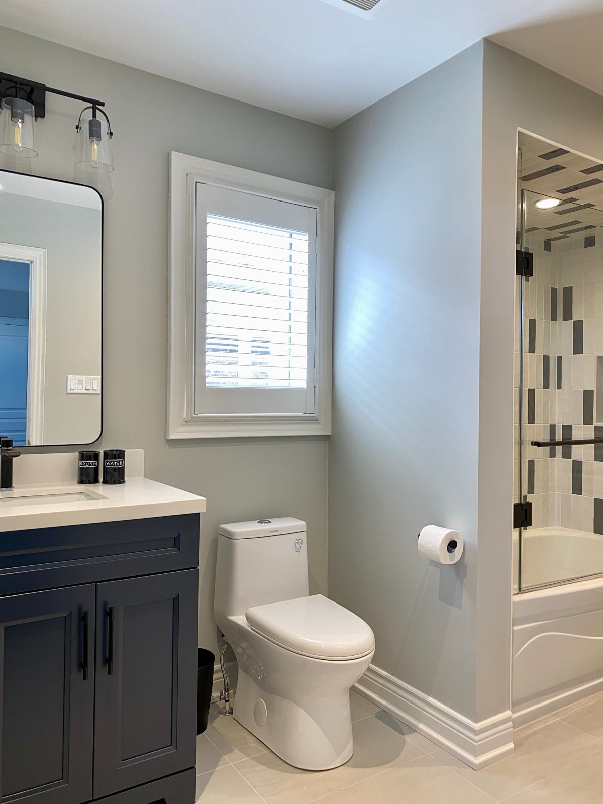 Renovated bathroom with navy vanity and matte black hardware